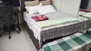 Un dormitorio con una cama, una silla y un escritorio.