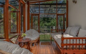 A cozy room with a wooden bed, a wicker chair, and a small table with a vase. - Sevena Villa: Magical Home with a Yoga Shala (Weligama)