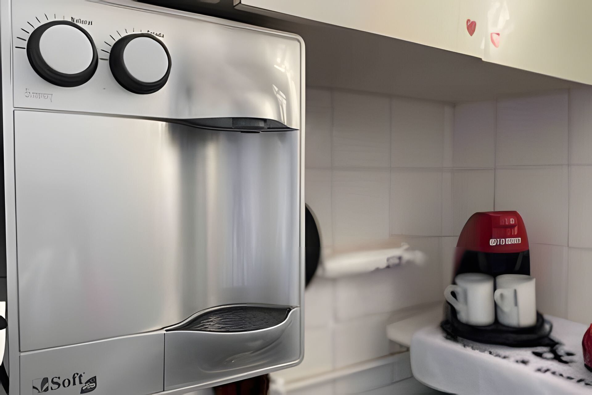 A kitchen with a coffee machine and a red coffee maker on the counter.