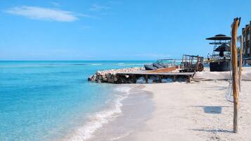 Playa en los alrededores, playa de arena blanca y sombrillas