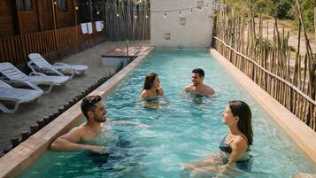 Una piscina al aire libre, tumbonas