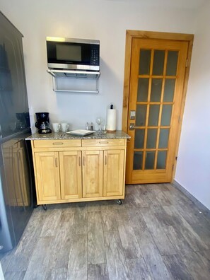 A compact kitchen with a microwave, coffee maker, and wooden cabinets. - Lockoff btw Beaver Creek & Vail (Avon)