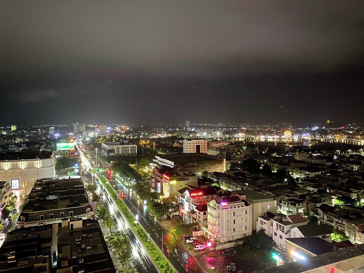 A nighttime cityscape with illuminated buildings and a busy street.