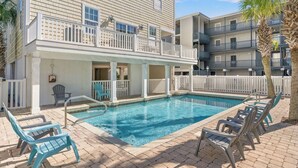 A pool area with a clear blue pool, lounge chairs, and a building with balconies. - Sleeps 44! Walk to Beach • Private Pool • BBQ (North Myrtle Beach)