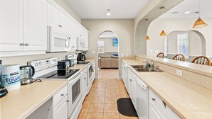 A modern kitchen with white cabinets, stainless steel appliances, and a central island. - Sleeps 44! Walk to Beach • Private Pool • BBQ (North Myrtle Beach)