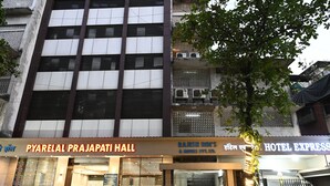 A hotel with a modern facade, multiple balconies, and signage for 'Pyarelal Prajapati Hall' and 'Rajesh Inn's Hotel Express.' - Hotel Express Airoli (Navi Mumbai)