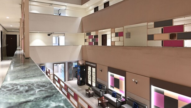 A multi-level hotel lobby with a marble floor, seating areas, and a 'GAYATRI BANQUET' sign. - Hotel Express Airoli (Navi Mumbai)