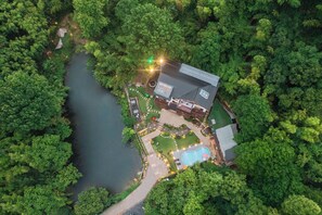 An aerial view of a house surrounded by dense forest, with a visible swimming pool and a well-maintained garden. - Shenshan Wild Escape (Huzhou)