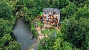 A multi-story house with a balcony, surrounded by dense forest and a river. - Shenshan Wild Escape (Huzhou)
