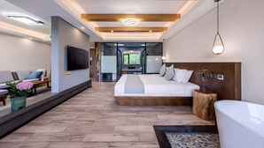 A modern bedroom with a large bed, a TV, and a seating area with a sofa and a coffee table. - Shenshan Wild Escape (Huzhou)