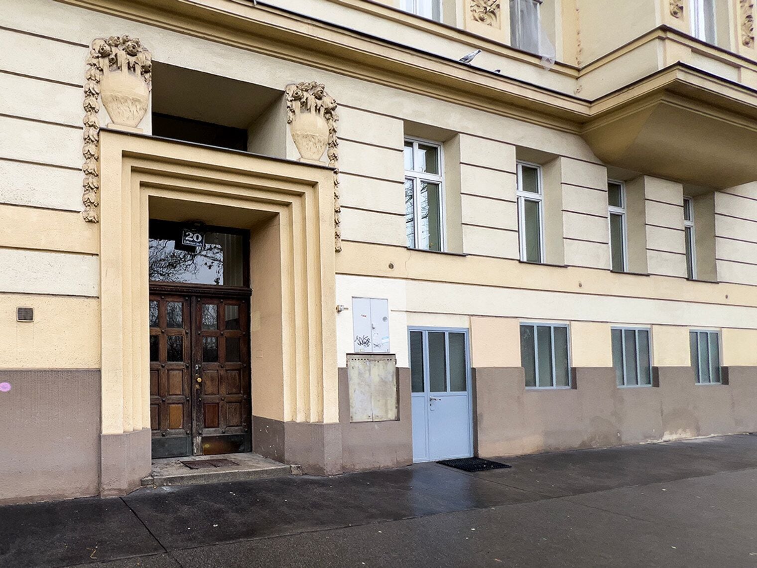 Ein Gebäude mit einer großen Holztür, einem kleinen Fenster und einem Klingel.