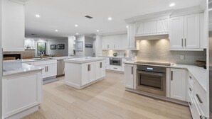 A modern kitchen with white cabinetry, a central island, and stainless steel appliances. - Fountainhead Listing Before Removing due to Annual Requirement (Naples)