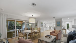 A spacious living area with a dining table, sofas, and a kitchen in the background. - Fountainhead Listing Before Removing due to Annual Requirement (Naples)
