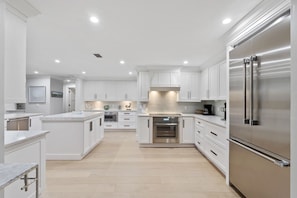 A modern kitchen with white cabinetry, stainless steel appliances, and a central island. - Fountainhead Listing Before Removing due to Annual Requirement (Naples)