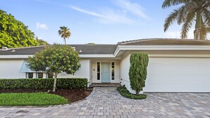 A modern two-story house with a paved driveway, a front door, and a garage. - Fountainhead Listing Before Removing due to Annual Requirement (Naples)