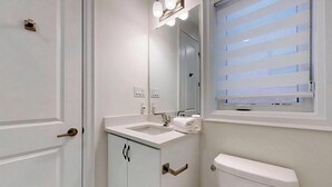A bathroom with a sink, mirror, and toilet. - A cozy getaway for a quiet relaxing spell. (Vaughan)