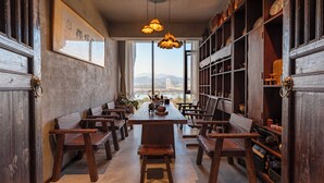 A dining area with wooden furniture, a large table, and hanging pendant lights.