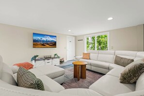 A living room with a sofa, a coffee table, and a painting on the wall.