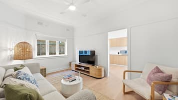 A modern living room with a sofa, coffee table, and a television.