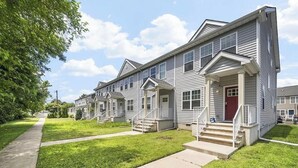 Un hilera de casas urbanas con porches delanteros y escalones que llevan a la entrada.