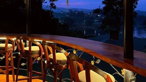Eine Bar mit Holzsesseln und Blick auf die Landschaft.