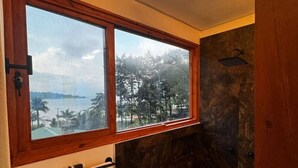 Ein Badezimmer mit einem großen Fenster, einer Dusche und einem Handtuchhalter.