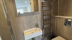 Ein modernes Badezimmer mit integriertem Waschbecken, Handtuchhalter und Toilette.