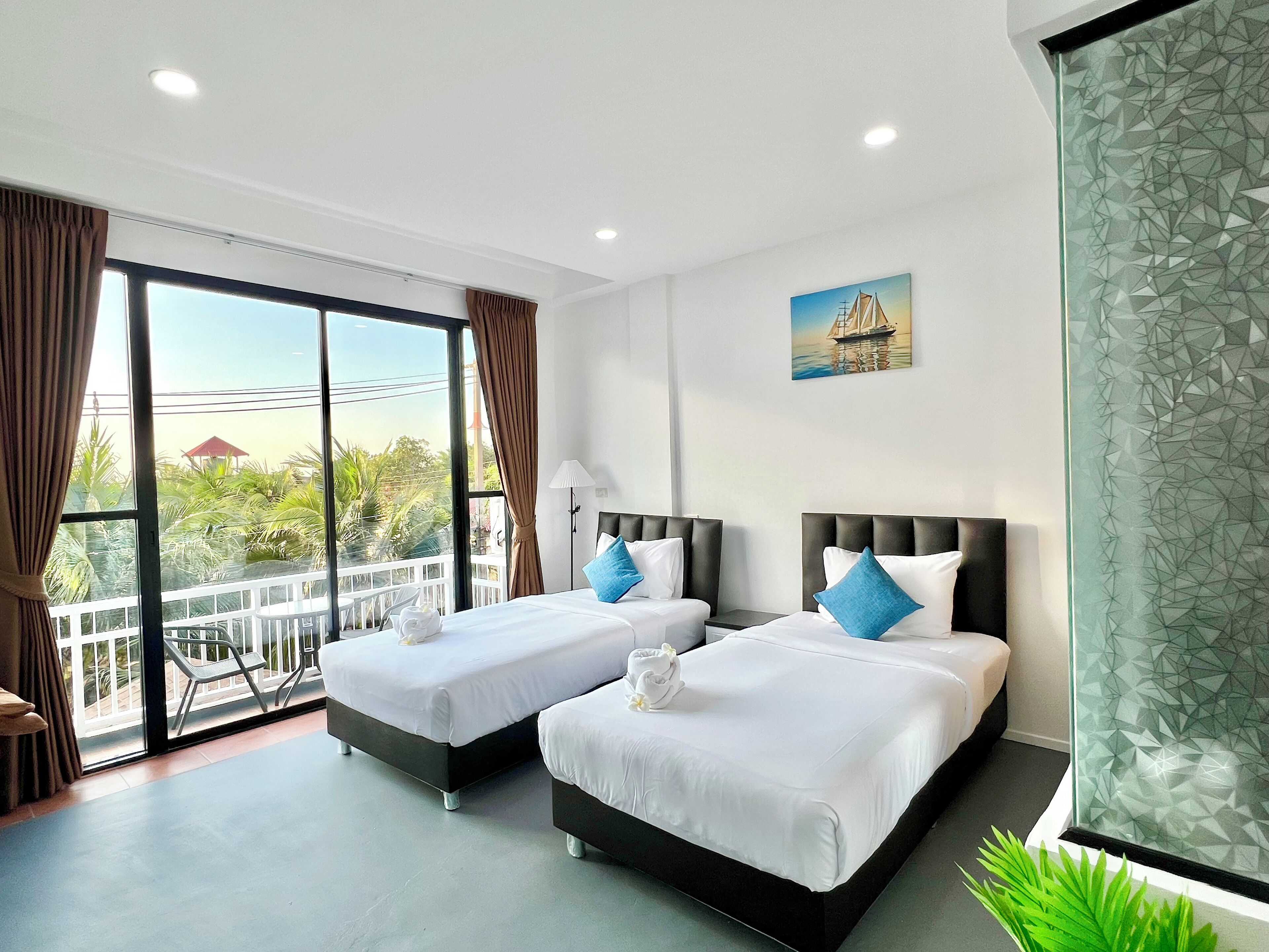 Habitación con 2 camas individuales, balcón, vista al jardín | Espacio para trabajar con laptop y tabla de planchar con plancha 