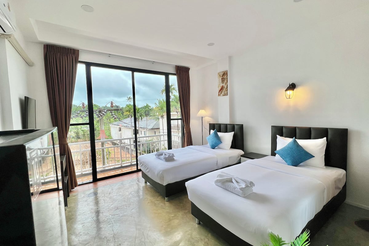 Habitación con 2 camas individuales, balcón | Espacio para trabajar con laptop y tabla de planchar con plancha