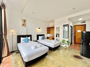 Habitación con 2 camas individuales, balcón | Espacio para trabajar con laptop y tabla de planchar con plancha