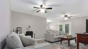 Ein Wohnzimmer mit einer Couch, einem Couchtisch und Deckenventilatoren.