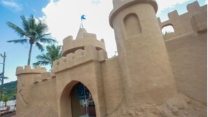 A castle-like structure with a central archway and towers, surrounded by palm trees. - Badaró's Beach Relax near the beach, 5 minutes from Mallet, shopping, and pet-friendly. (Praia Grande)