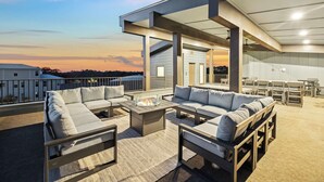 Una terraza en la azotea con mobiliario exterior, un brasero y vistas del horizonte de la ciudad.