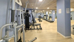 Kuntosali, jossa on kuntopyörät, painonnostovälineet ja juoksumatto.