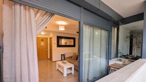 Moderni olohuone, jossa on sohva, sohvapöytä ja lasiseinä.
