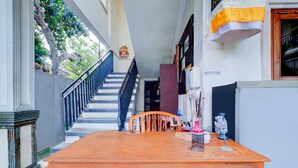 Un espace d’accueil avec un bureau en bois, une chaise et un escalier menant à l’étage supérieur.