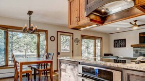 Una cucina moderna con mobili in legno, un'isola centrale e un'area pranzo con tavolo e sedie.