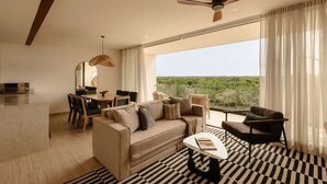 Ein modernes Wohnzimmer mit einer Couch, Sesseln, einem Esstisch und einem Deckenventilator.
