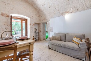 Ein Zimmer mit Esstisch, Stühlen, einer Couch und einer Küchenzeile.