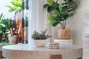 A round table with a potted plant and a stack of coasters. - Noosa River 2BD Townhouse - Modern & Stylish (Noosa)