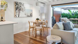 Un interior moderno con comedor, sofá y vistas al exterior.