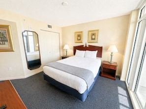Ein Hotelzimmer mit einem Bett, einem Nachttisch, einem Spiegel und zwei gerahmten Bildern an der Wand.