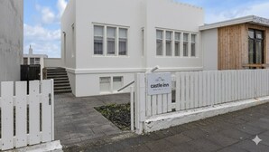 A white building with a castle-like facade, a gated entrance, and a sign reading "castle inn."