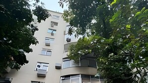 Un immeuble à plusieurs étages doté de balcons et de climatiseurs.