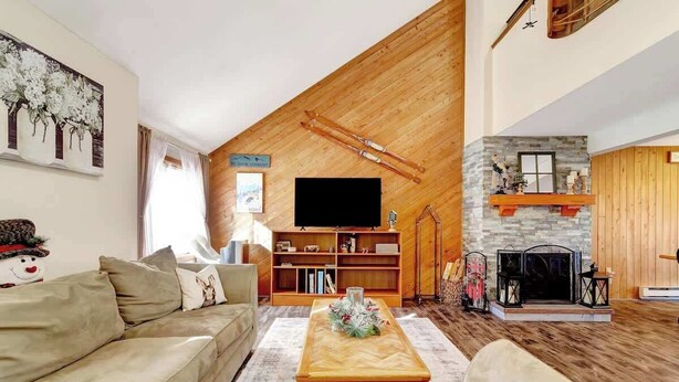 A cozy living room with a wooden ceiling, a fireplace, a television, and a bookshelf. - Crosstown Retreat | 2 Miles to Mt Snow w Fireplace (Dover)