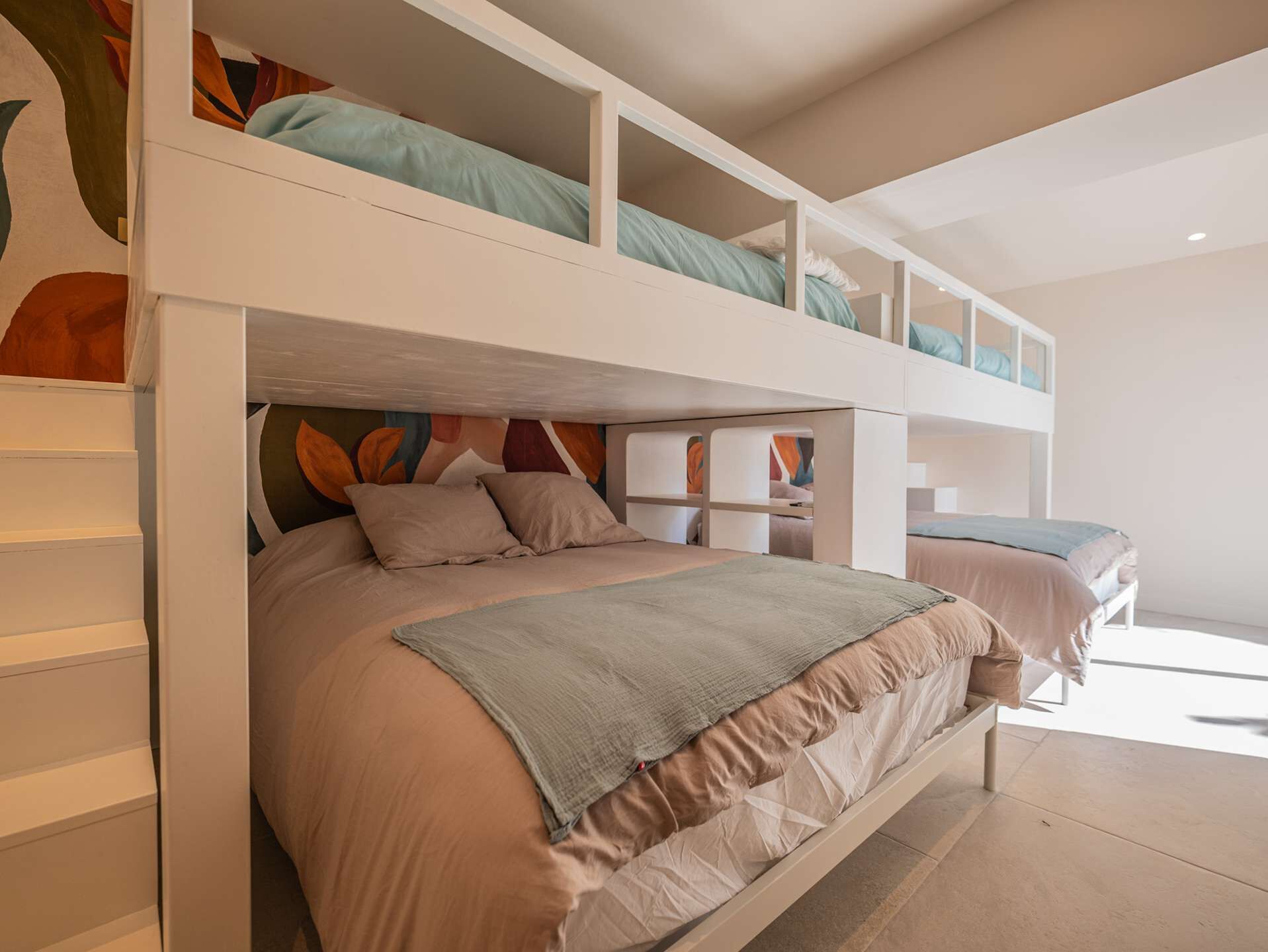 A bunk bed room with a lower bed and a loft bed above.