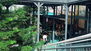 A multi-level indoor space with a glass enclosure, metal railings, and greenery. - Rose Hill Villa Dalat (Cam Ly - Da Lat)
