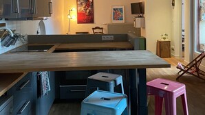 A modern kitchen with a central island, pendant lights, and a dining area with stools. - Bucolic apartment - Historic heart of Dijon (Dijon)