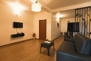 Deluxe négyágyas szoba | Nappalirész | 32 hüvelyk képátmérőjű tévé, amelyen többféle kábelcsatorna nézhető