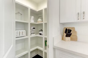 A white kitchen with white cabinets, a coffee maker, a toaster, and a knife block. - Keolu Hills Haven: Renovated 2/2 & Easy Parking (Kailua)